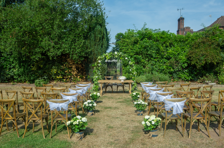Garden ceremony space with wooden chairs and floral accents, perfect for intimate weddings at Stone Manor.