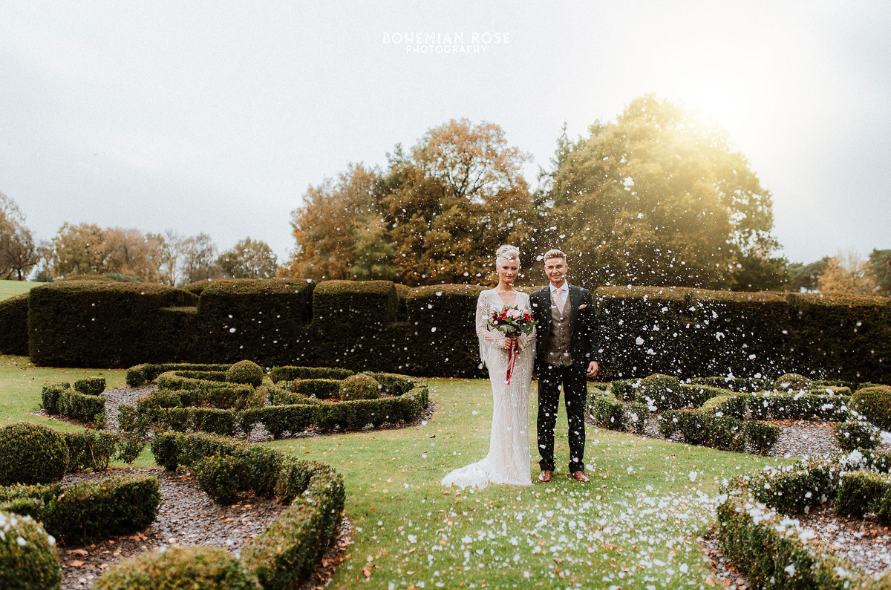 Newlyweds standing in the manicured gardens during golden hour, a picture-perfect scene from weddings at Stone Manor.