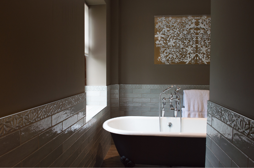 Contemporary bathroom at Stone Manor with a deep freestanding tub and decorative wall art.
