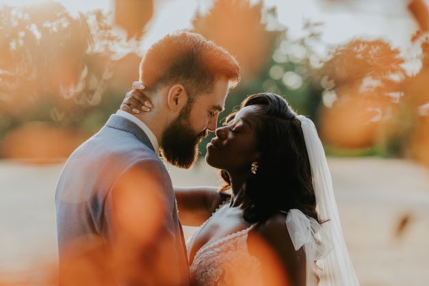 Bride and groom sharing an intimate moment surrounded by natural light and soft autumn tones at Stone Manor.