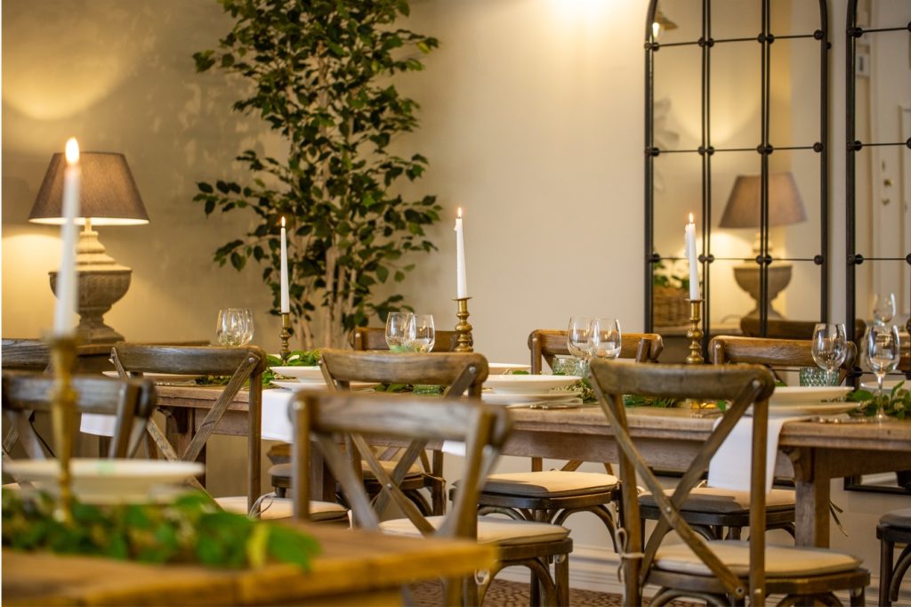 Cosy wedding reception space at Stone Manor with warm lighting, candles, and rustic wooden tables.