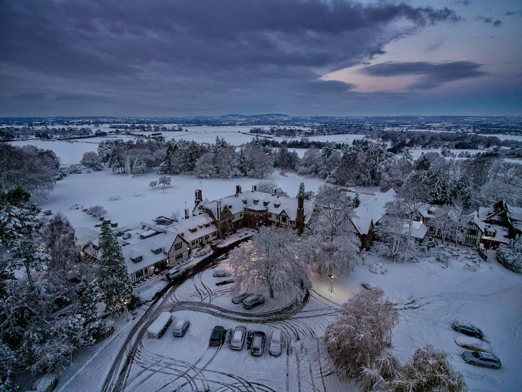 Aerial winter view of Stone Manor covered in snow, highlighting its beauty for seasonal weddings.